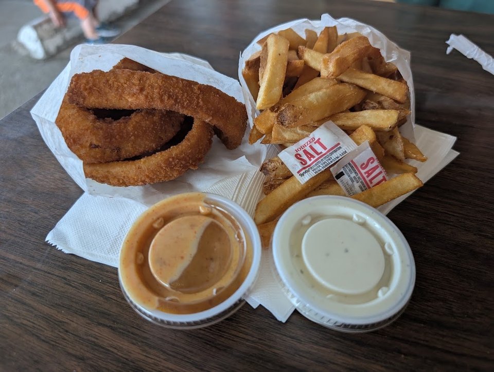 Counter menu with hamburgers and onion rings.